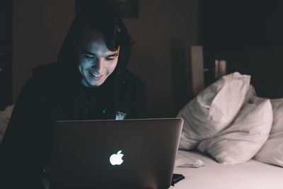 在床上使用MacBook的人